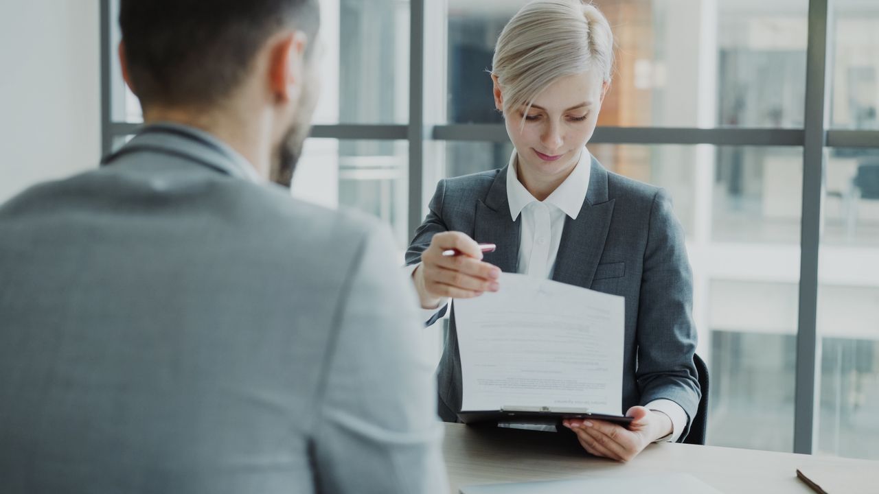 Mastering the First Impression: Your intriguing post title goes here Business professionals reviewing a contract in a modern office setting.